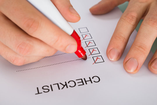 Person Hand Marking On Checklist Form