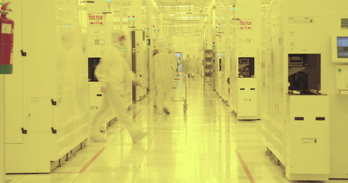 Workers in clean suits in a semiconductors manufacturing facility