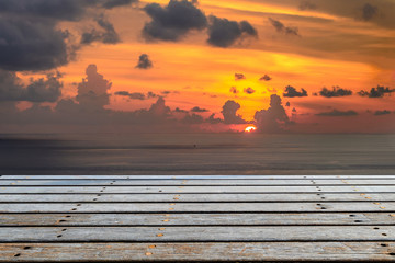 Fototapeta na wymiar Wooden platform beside tropical sea with sunset