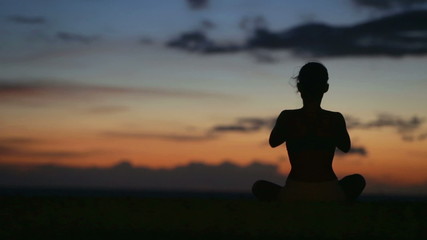 Yoga meditation woman meditating at beach sunset or sunrise relaxing in yoga pose. Serene relaxed female yoga instructor in calm nature sea scene.