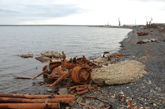 Old rusty abandoned metal vehicle parts at arctic sea coast
