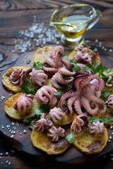 Octopuses served with baked potato in spanish galician style