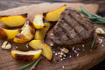 Close-up of grilled filet mignon beefsteak with potato wedges