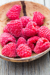 Frozen raspberries on wooden background.