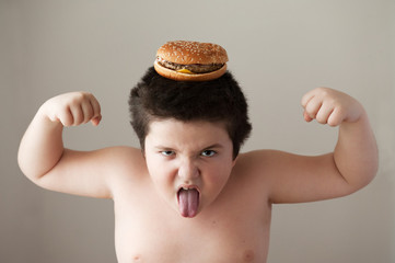 fat boy with  burger on  head showing muscles and   tongue