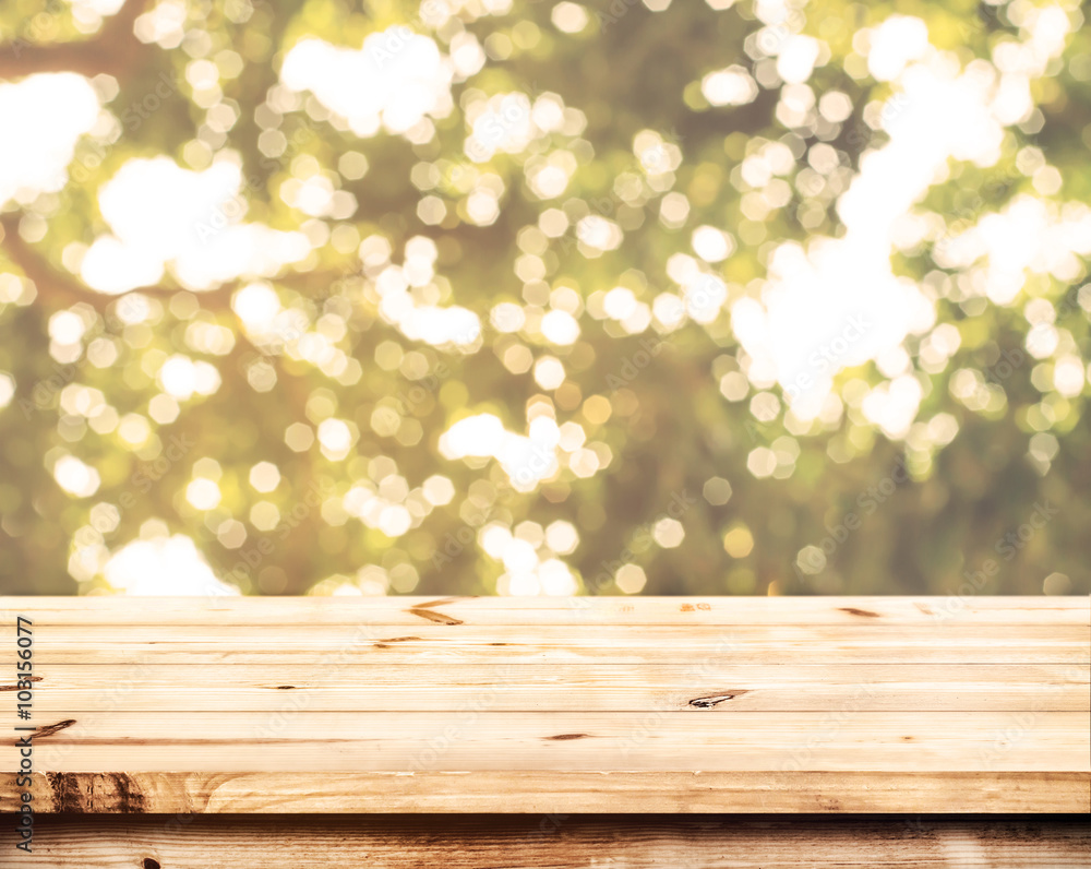Wall mural top of wood table with blurred bokeh nature background - empty ready for your product display or mon