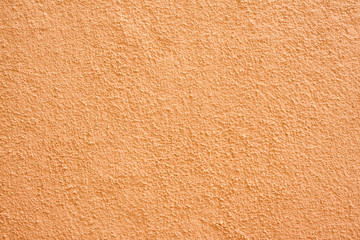 Stucco wall - Orange stucco textured wall background with natural light.