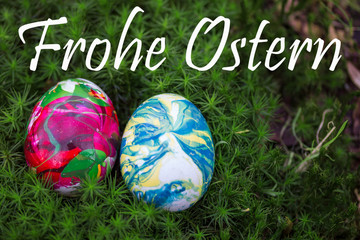 zwei Ostereier im Moos, die Eier wurden mit Nagellack gefärbt