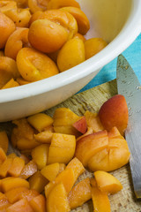 Aprikosen gewürfelt und zum Kochen vorbereiten auf einem Holzbrett mit einem Messer