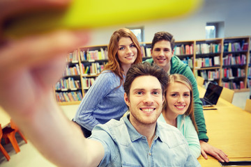 students with smartphone taking selfie in library