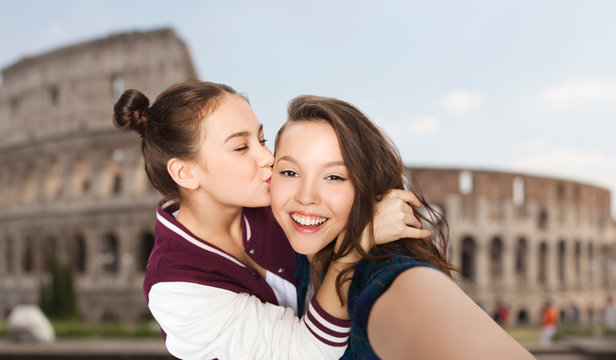 happy teenage girls taking selfie over coliseum