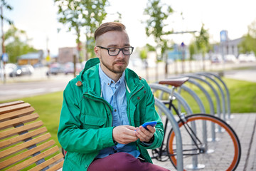 Fototapeta premium happy young hipster man with smartphone and bike