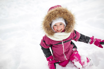 f happy little child or girl with snow in winter