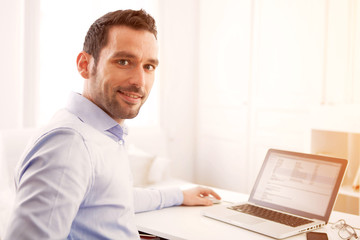 Young business man working at home on his laptop