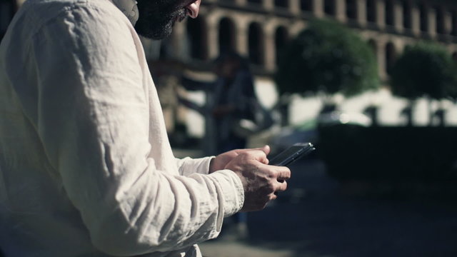 Man hands texting on smartphone in the city
