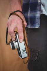 View of masculine hands holding a retro camera