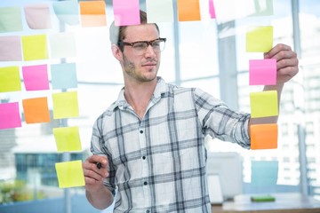 Hipster man looking at post-it