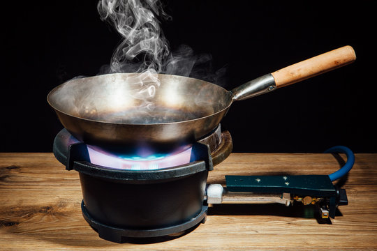 chinese wok pan on fire gas burner