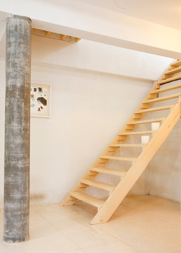 Wooden stair with concrete pillar and white wall