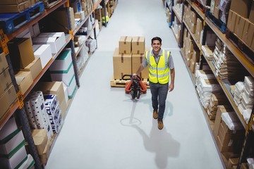 Worker pulling trolley with boxes