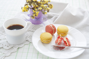 Colorful french macaroons and white coffee cup with soft vintage color