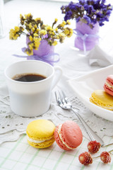 Colorful french macaroons and white coffee cup with soft vintage color