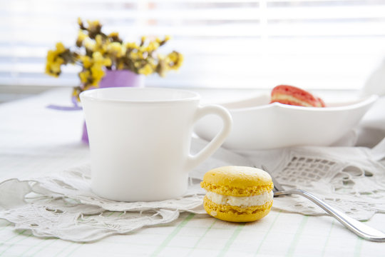 Colorful french macaroons and white coffee cup with soft vintage color