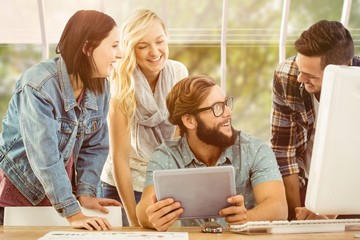 Composite image of happy business people using digital tablet