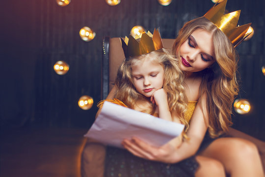 Beautiful princess mother and daughter in a gold crown