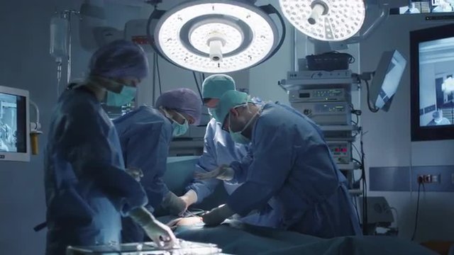 Medical Team Performing Surgical Operation in Modern Operating Room. Shot on RED Cinema Camera.