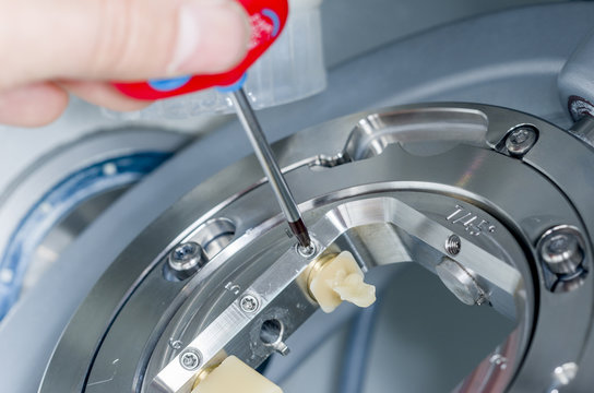 Dental technician unscrew the hybrid ceramics the milling machin