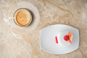 White cake with raspberry and coffee on the stone table