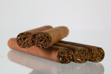 Different cigars on a  glass desk