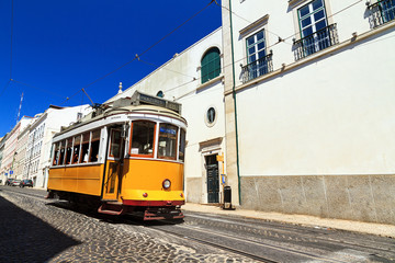 Fototapeta na wymiar Beautiful traditional yellow tram in the streets of Lisbon, Portugal, in summer