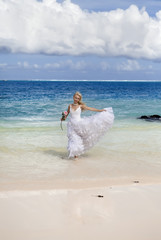 Fototapeta na wymiar beautiful woman in a wedding dress in the sea