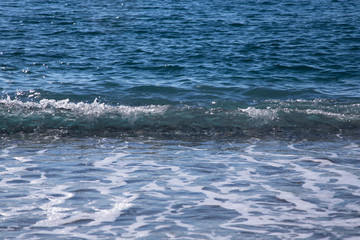 Naklejka na ściany i meble Wave on the pebble coast of sea. Selective focus