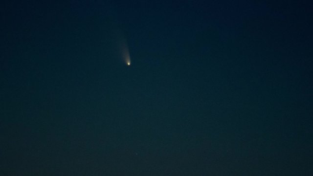A comet moving across the evening sky