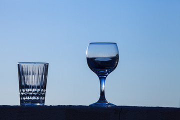 Glass of water on the background of beautiful sunset. Selective