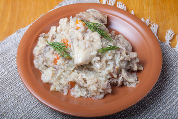 Rice with chicken on a clay plate on linen napkin