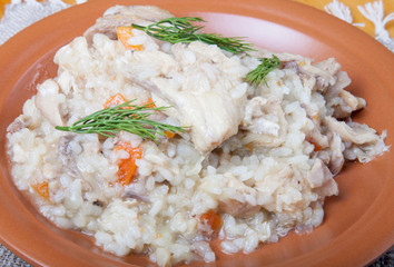 Rice with chicken on a clay plate on linen napkin. Selective foc