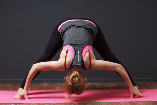  Yoga. Deep bend with straddled legs. Woman doing workout.