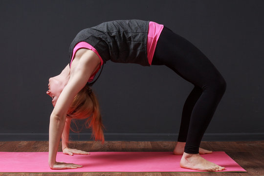 Young blonde woman staying in bridge pose