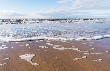 Fototapeta premium relaxing and gentle calming waves flowing into a beach at sundown