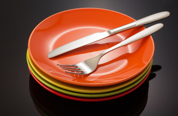 knife and fork at plate on black