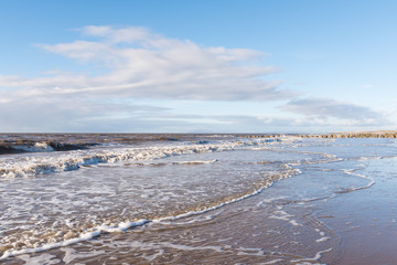 relaxing and gentle calming waves flowing into a beach at sundown