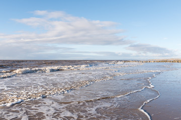 relaxing and gentle calming waves flowing into a beach at sundown