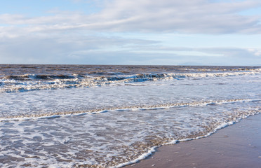 relaxing and gentle calming waves flowing into a beach at sundown