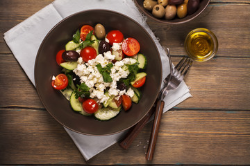 Traditional greek salad with fresh vegetables, feta cheese and olives. Top view. Rustic style. Selective focus