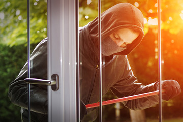 Burglar breaking in a house