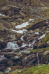 Mountain stream rapids flowing down among rocks nearby the famous Transfagarasan road in Fagaras mountains, Romania. Long exposure motion blur.